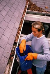 woman cleaning gutters