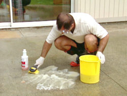 Man demonstrating how to get stains out of concrete