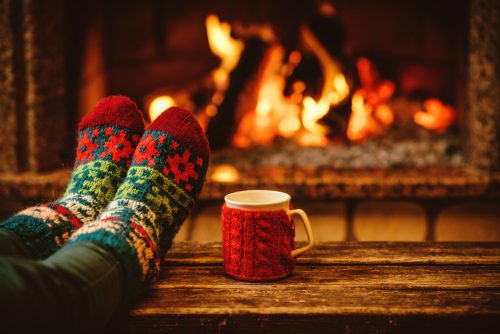 hygge feet in socks in front of fireplace